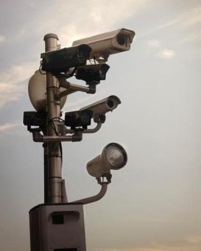 Surveillance cameras against ominous cloudy sky