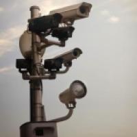 Surveillance cameras against ominous cloudy sky